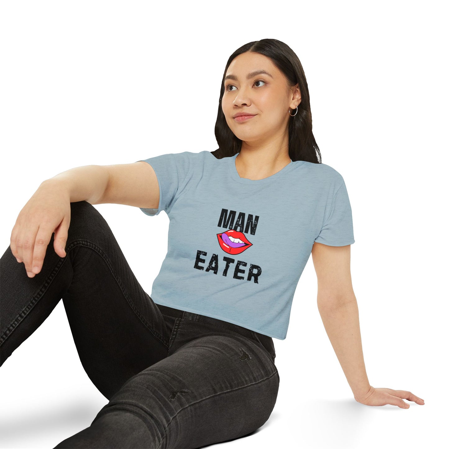 Woman wearing my light blue t-shirt with  text "man eater", sitting 